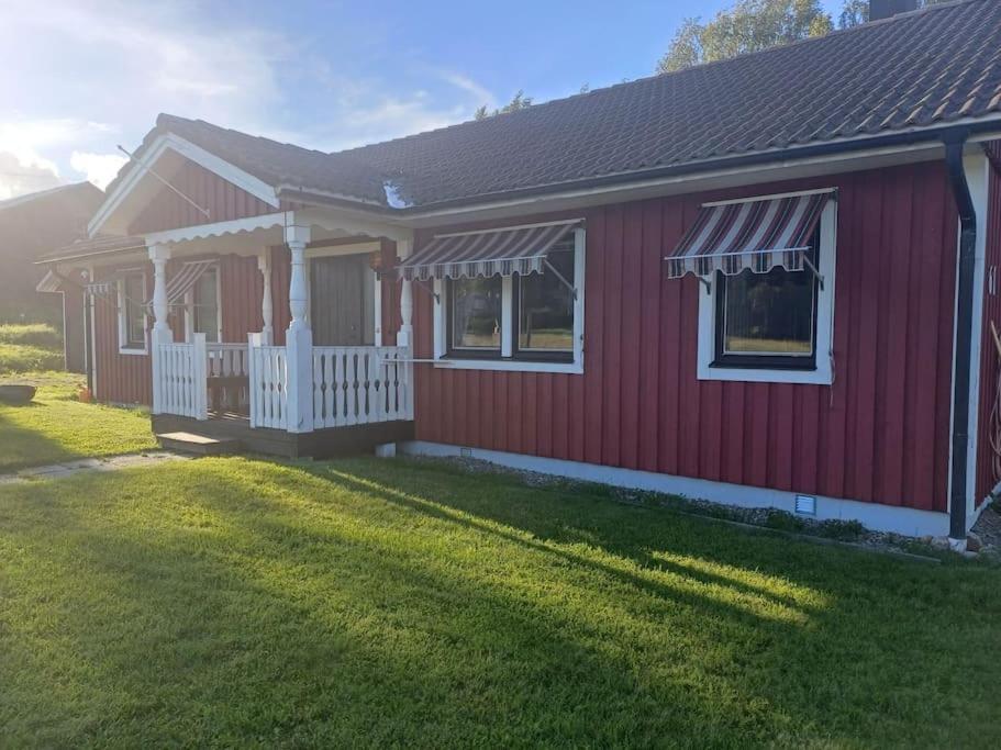 ein rotes Haus mit einem weißen Zaun in der Unterkunft Hus i lugn och naturskön miljö in Ockelbo