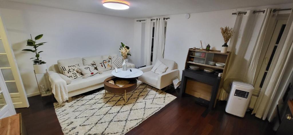 uma sala de estar com um sofá branco e uma mesa em Austerlitz Cocoon em Paris
