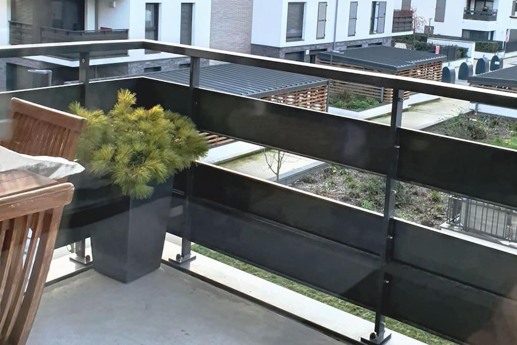 a balcony with a black railing and a plant at Appartement avec Balcon Pontoise PARIS Nord-ouest in Pontoise