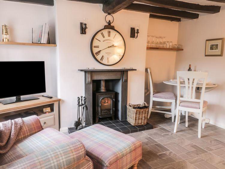 una sala de estar con un reloj grande en la pared en Stone Cottage, Idyllic Village en Ingham