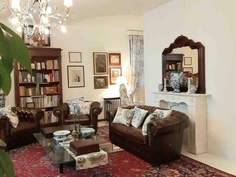 un soggiorno con divani in pelle e camino di La Villa Bianca - appartamento in villa a Sesto Fiorentino