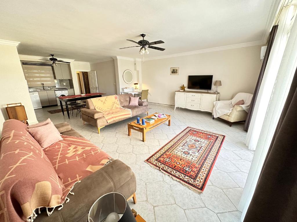 a living room with a couch and a tv at Merkeze Yakın, Ev Rahatlığında in Marmaris