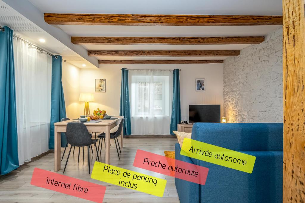 sala de estar con sofá azul y mesa en L'écrin authentique, en Audincourt