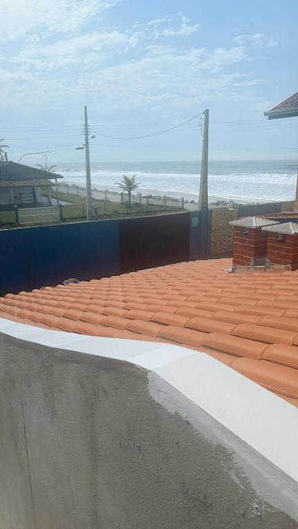 a brick patio with the beach in the background at PÉ NA AREIA Apto Vicenzo in Itapoa