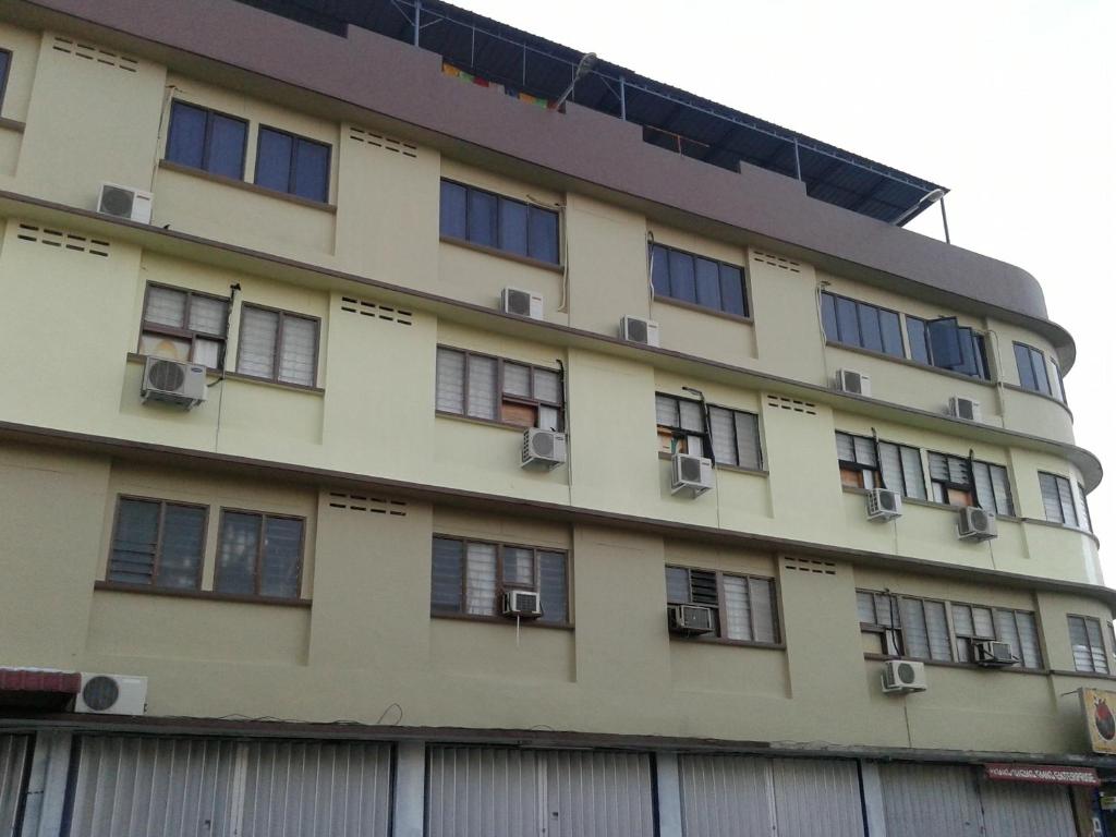an apartment building with windows and a fence at HotelMalaya in Taiping