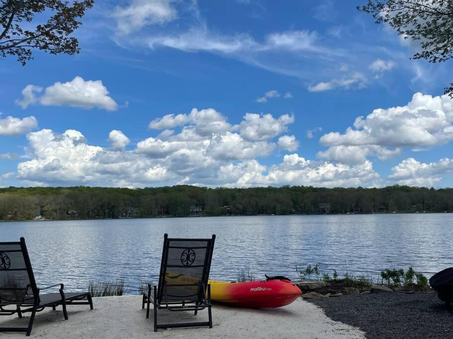 zwei Stühle und ein Kajak am Ufer eines Sees in der Unterkunft Lakeside Oasis with Kayaks, Hot Tub, & Fire Pit 