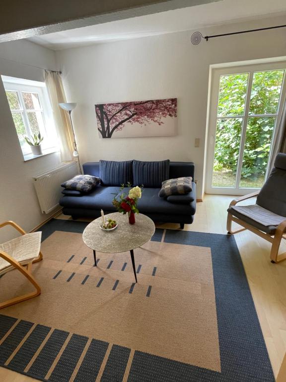 sala de estar con sofá azul y mesa en Ferienwohnung Südliche Weinstraße zwischen Wald und Reben en Klingenmünster