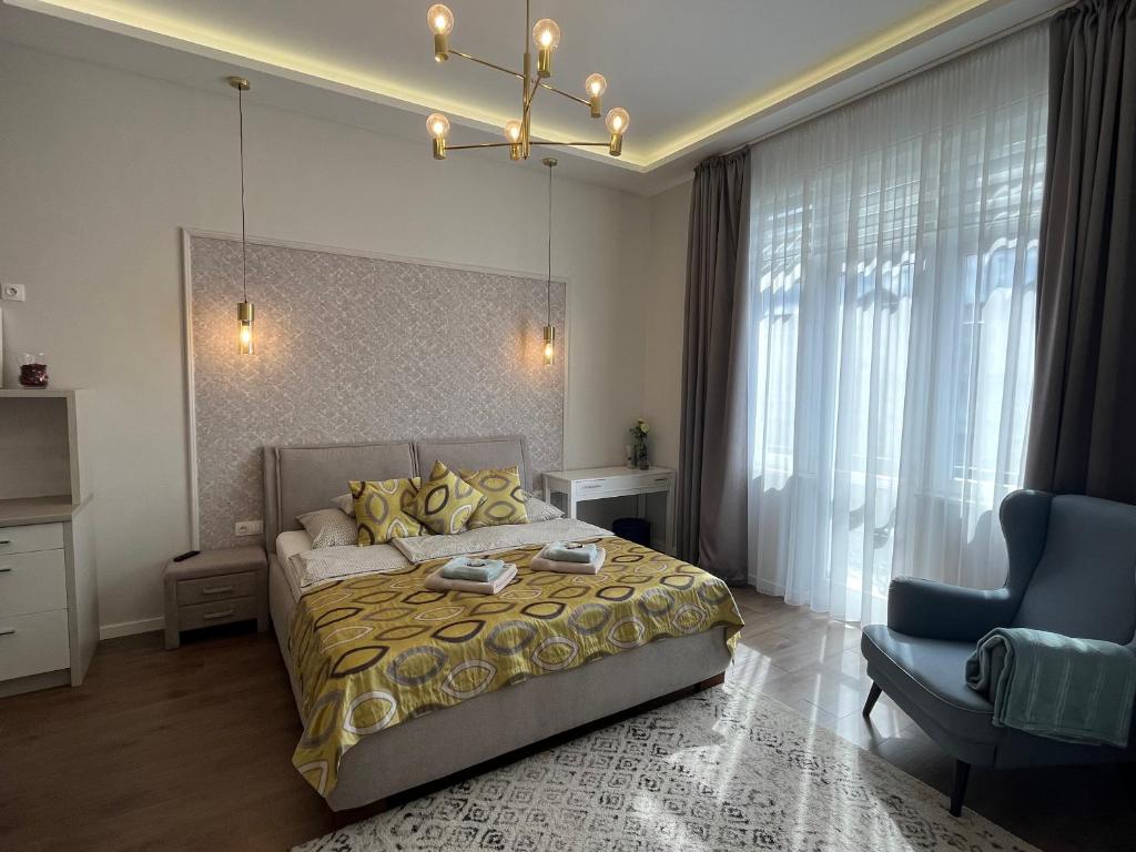 a bedroom with a bed and a couch and a chair at Visit Debrecen Apartman in Debrecen
