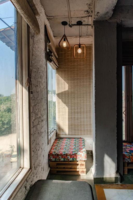 a window seat in a room with two windows at JHouse near Bhikaji in New Delhi