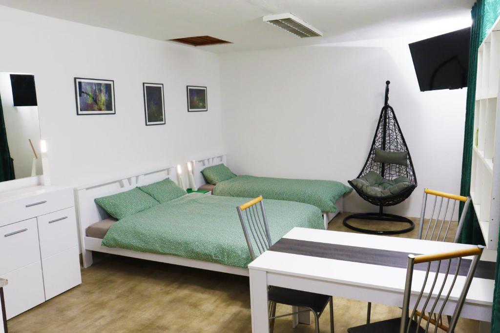 a bedroom with a bed and a table and a desk at STUDIO STUDIO + in Vrbas