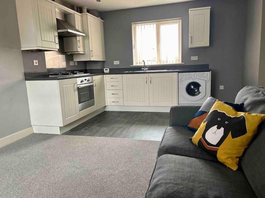 uma sala de estar com um sofá e uma cozinha em The Gainsborough Mews-stylish & modern (sleeps 3) em Lincolnshire