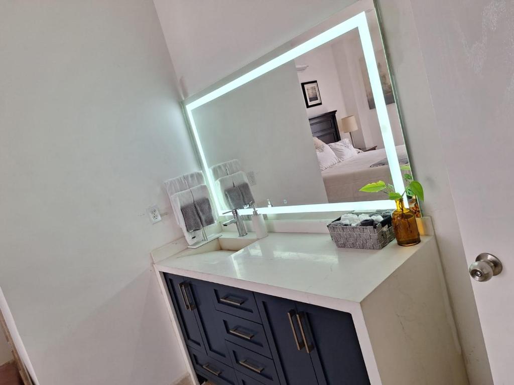 a bathroom with a sink and a large mirror at Rosarito Beach condominio in Rosarito