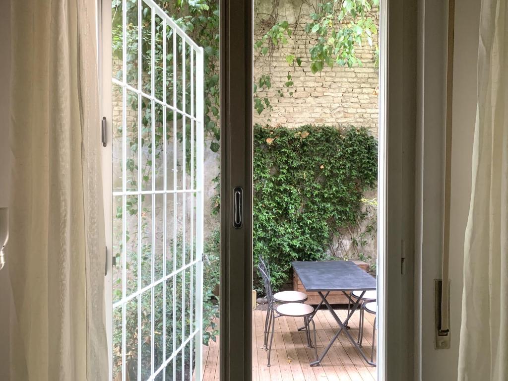 an open door to a patio with a table outside at Il Giardino Segreto in Parma