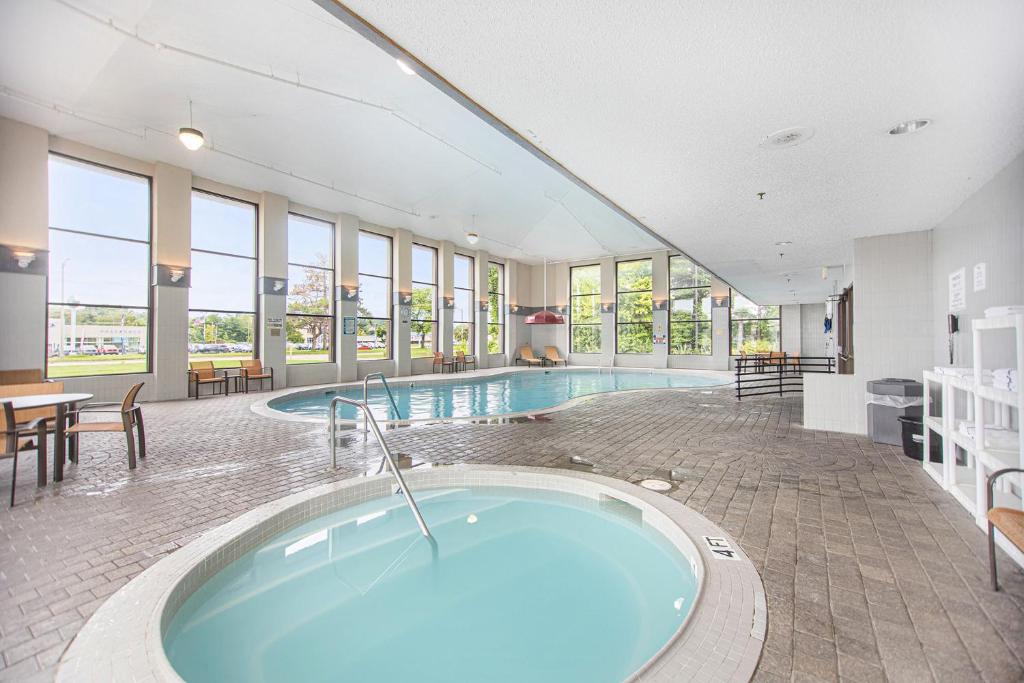 a large pool with a hot tub in a building at Baymont by Wyndham Grand Haven in Grand Haven