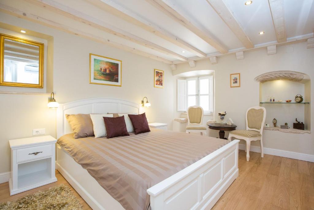 a bedroom with a large white bed and a bathroom at Studio Apartments Sonatina in Dubrovnik