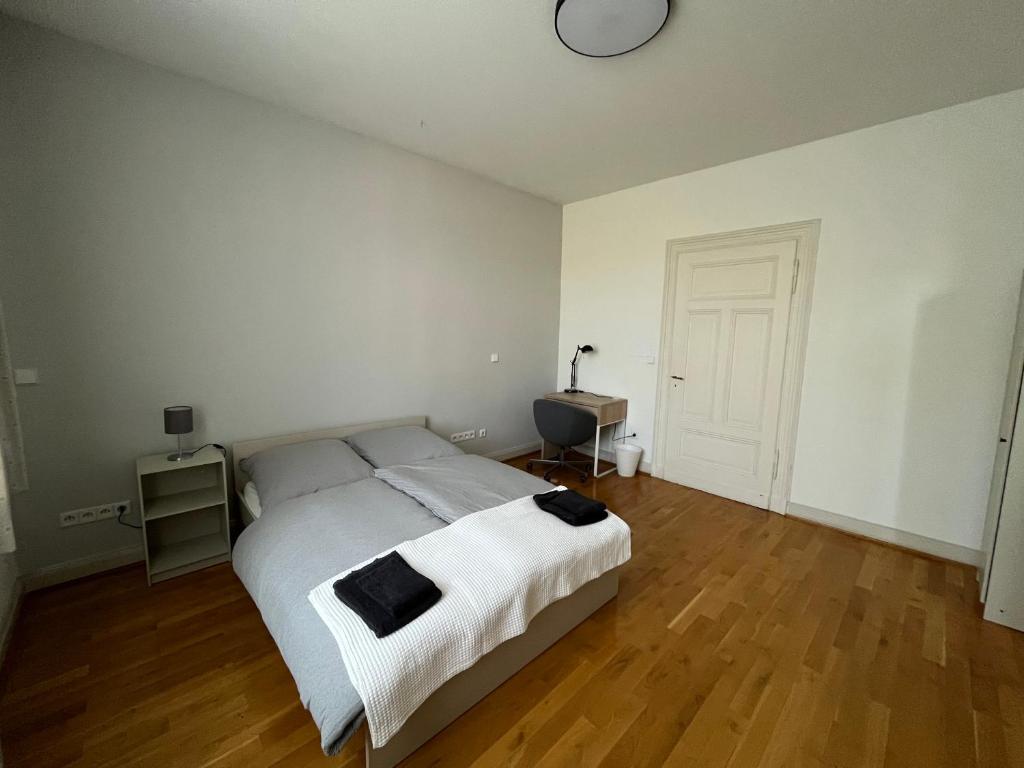 1 dormitorio con cama blanca y suelo de madera en Ruhe-Oase, en Herne