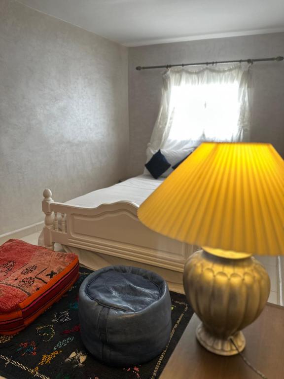 a bedroom with a bed with a lamp and a ottoman at House with sea view in Kasbah in Tangier