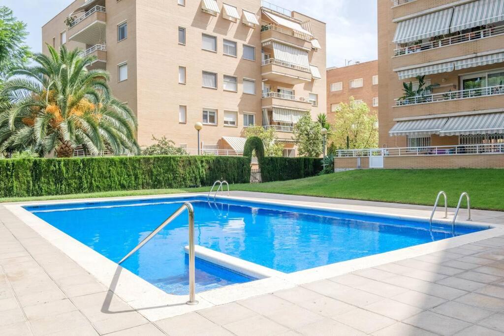 a swimming pool in front of a building at Apartamento en complejo residencial, con piscina. in Salou