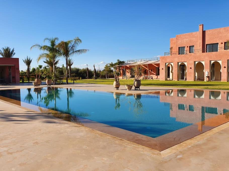 a swimming pool in front of a building at Dar Lalla Mhalla Villa 975m2 5ch - Rt de Fes in Marrakesh