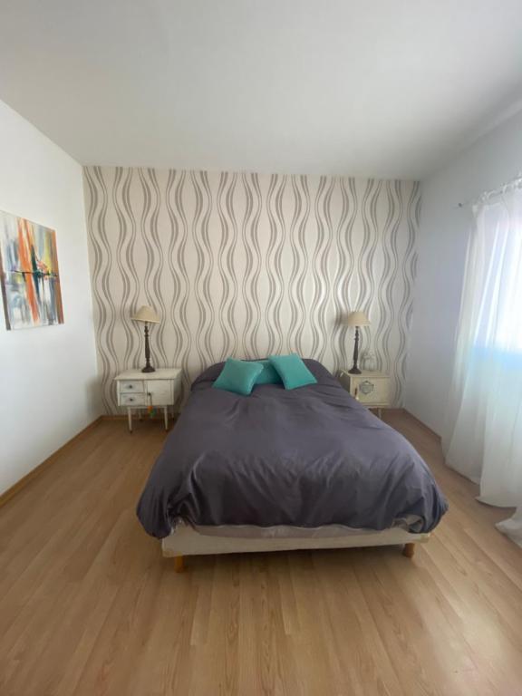 a bedroom with a bed and two tables with lamps at Puerta 460 in Barraquero