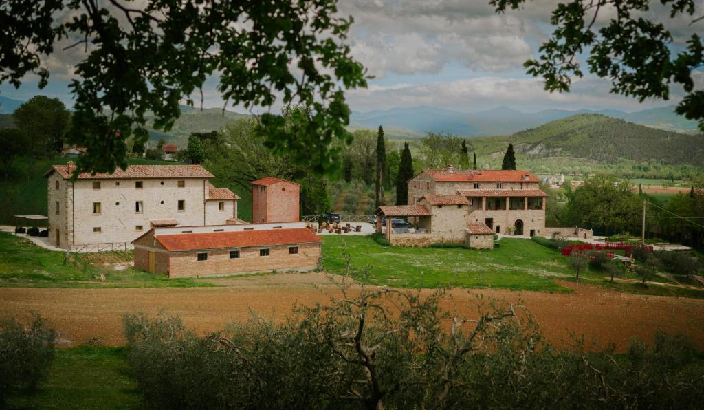 un groupe de bâtiments avec des montagnes en arrière-plan dans l'établissement Agriturismo Podere Tovari, à Anghiari