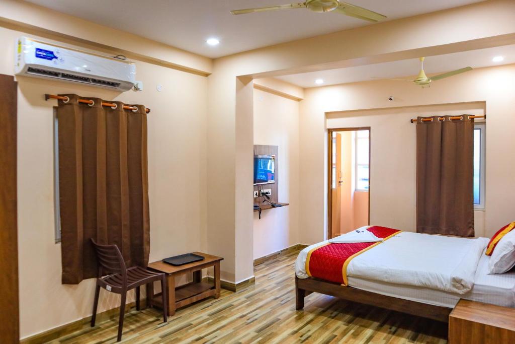 a bedroom with a bed and a chair in it at Hotel Radha Krishna in Visakhapatnam