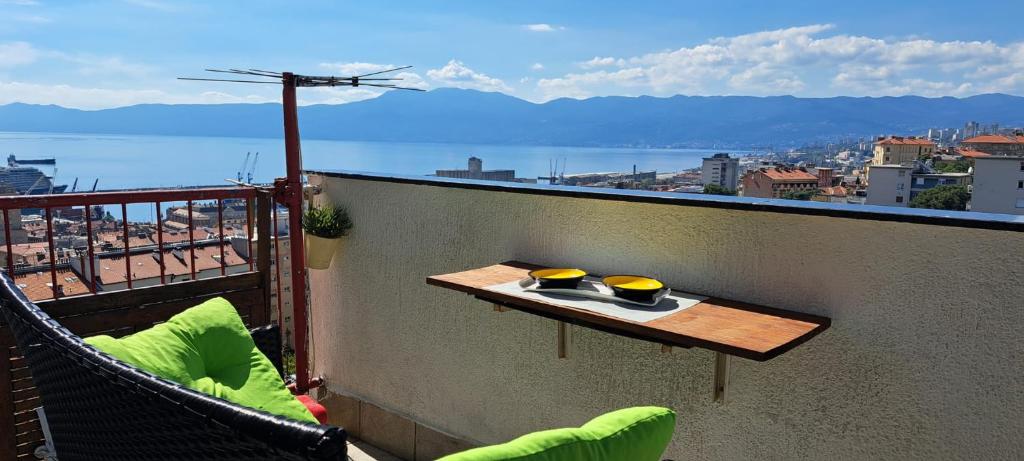 Una mesa en un balcón con vista a una ciudad. en Sentona Apartment, en Rijeka