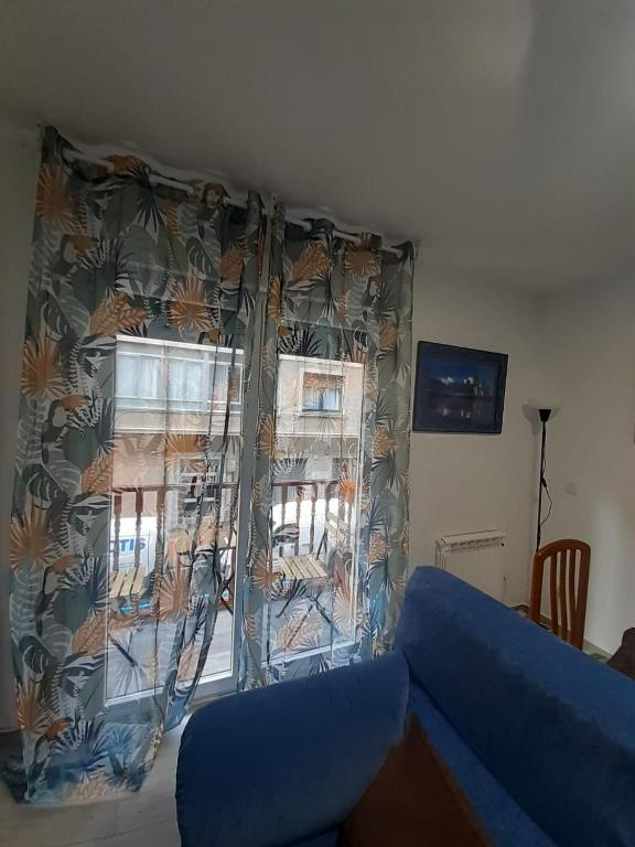a living room with a blue couch and a window at BEC,CASA BARAKALDO al lado del BEC in Barakaldo