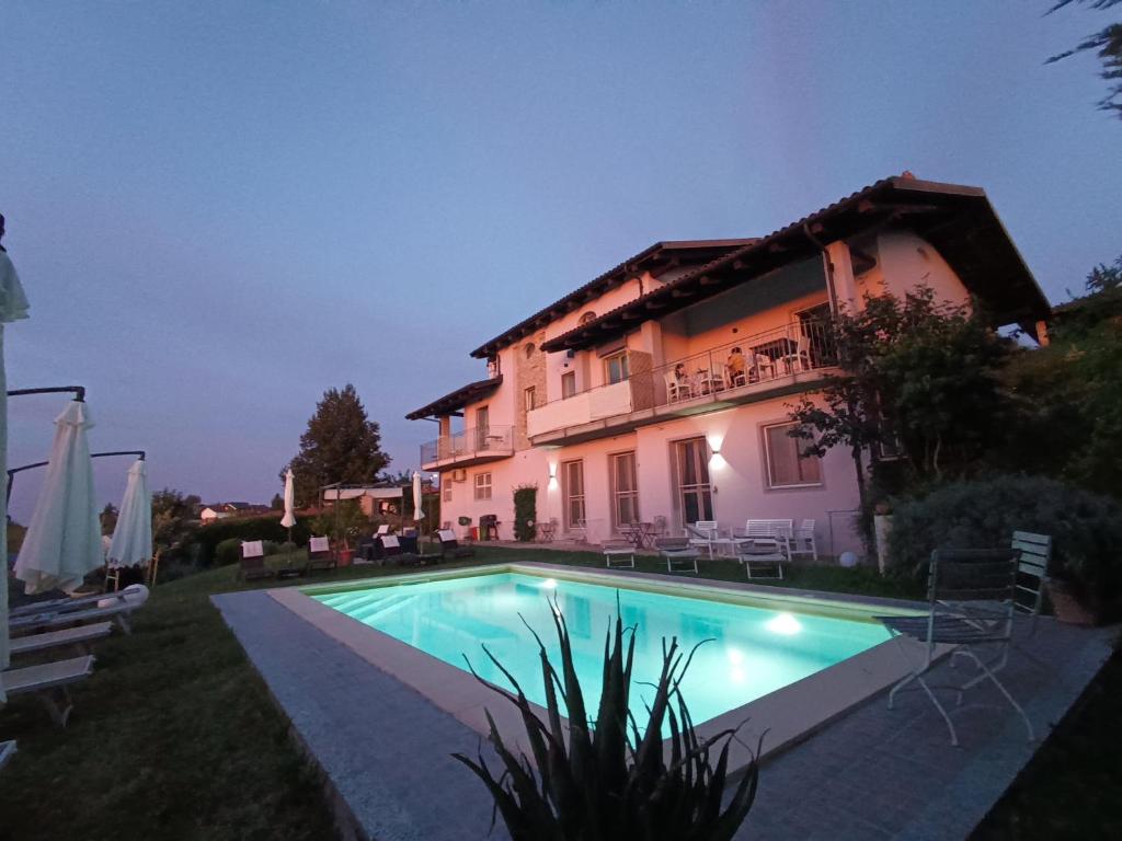 a villa with a swimming pool in front of a house at Domus Langhe B&B in Treiso