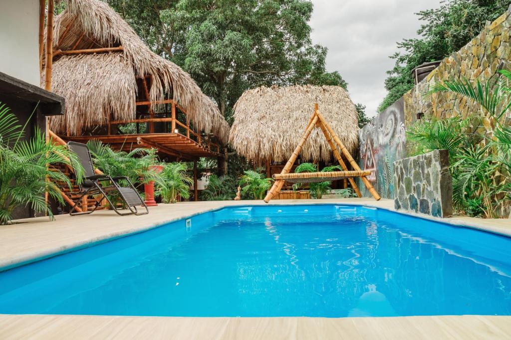 a pool at a resort with a thatched roof at Kasakolà in Palomino