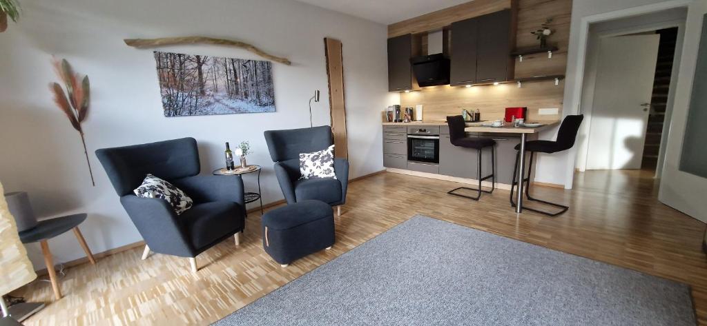 a living room with chairs and a table and a kitchen at Place2be in Calden