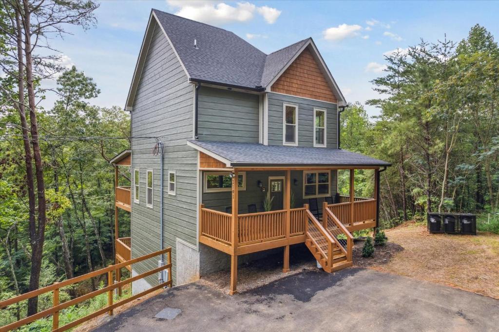 a tiny house with a porch and a deck at Chasing the Son Cabin cabin in Sevierville