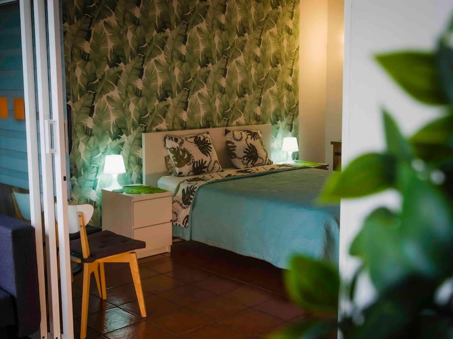 ein Schlafzimmer mit einem Bett, einem Tisch und einem Stuhl in der Unterkunft Apartamento en Puerto de la Cruz in Puerto de la Cruz