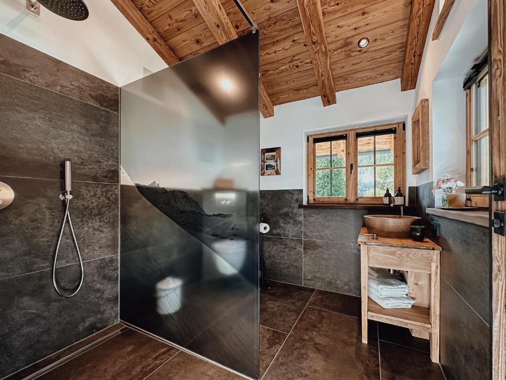 La salle de bains est pourvue d'une douche et d'un lavabo. dans l'établissement Chalet Nordic mit privatem Whirlpool und Sauna, à Bayrischzell