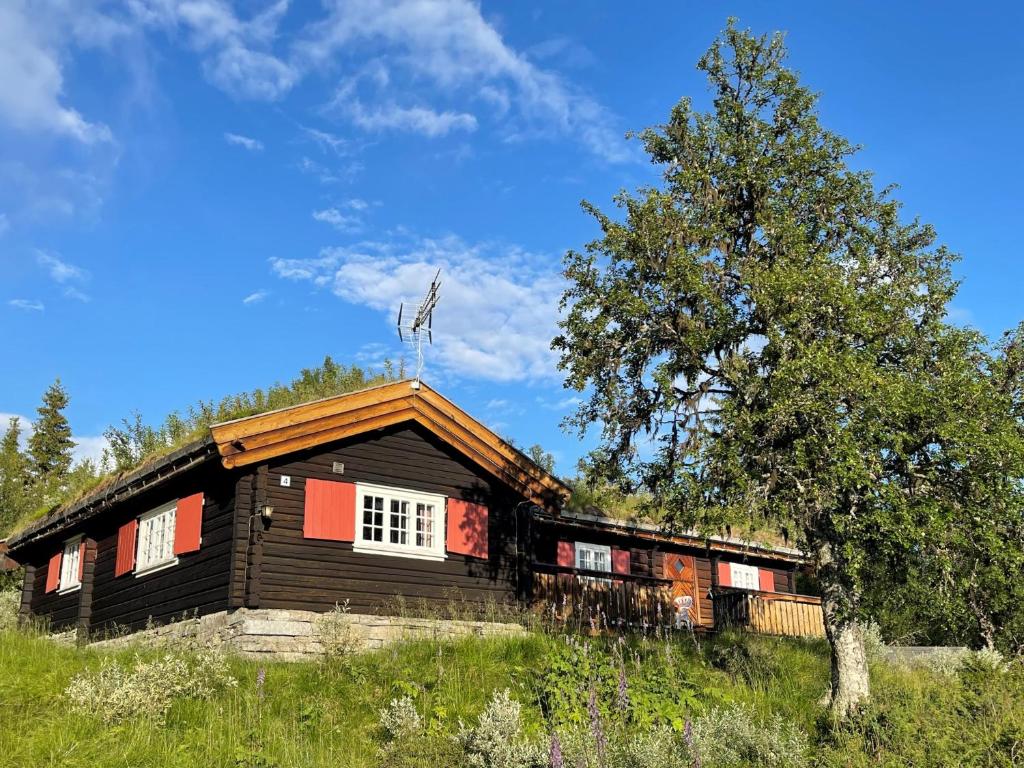 Cabaña de madera con árbol y cielo azul en Elveseter - log cabin with an amazing view en Lunde