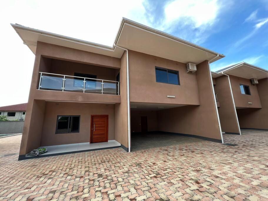 uma casa grande com uma entrada de tijolos em Njikale Serviced Apartments - 6 em Lusaka