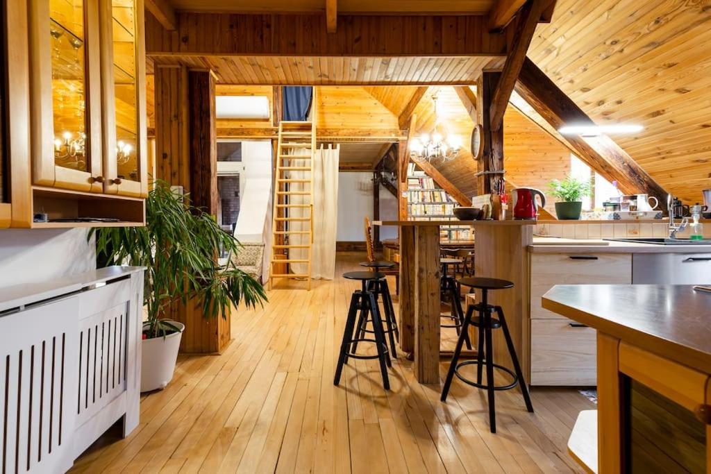 een keuken met houten vloeren en krukken in een kamer bij Rooftop 180m2 Loft with private SAUNA, in Bratislava