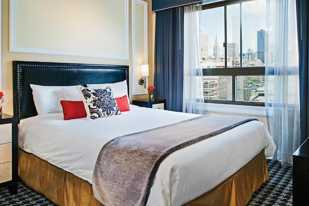 a bedroom with a large bed with a large window at Deluxe Union Square Suites in San Francisco