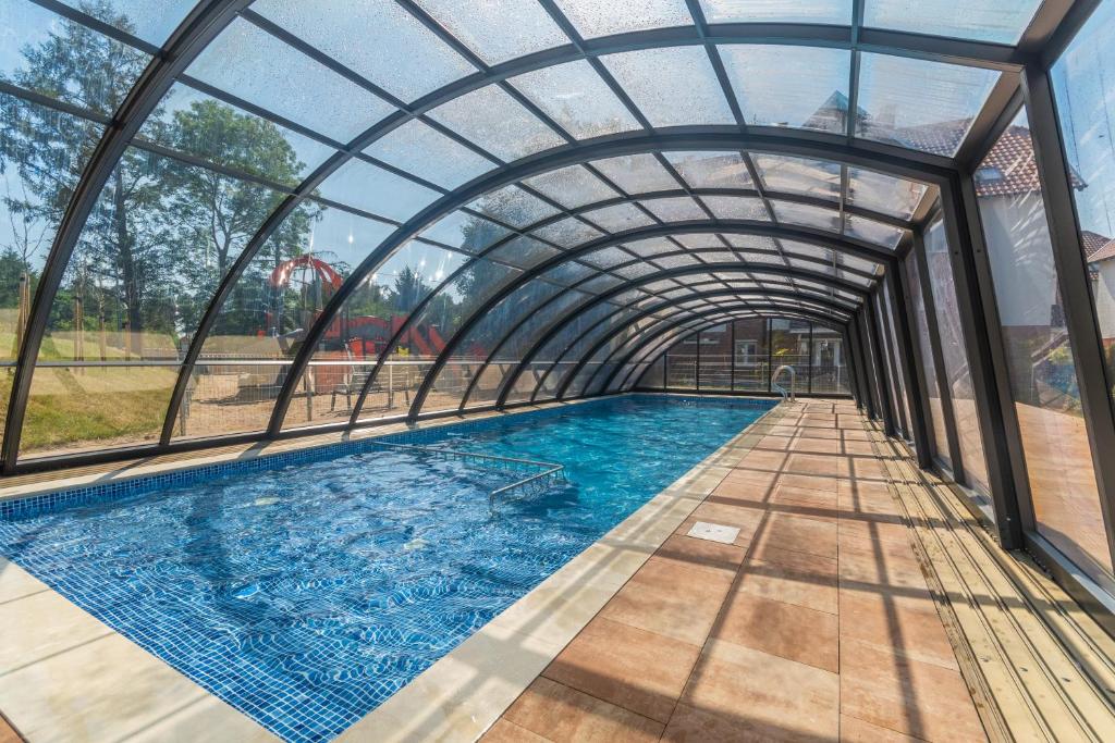 a swimming pool under an archway in a building at Apartament Baltic Garden&Sztutowo in Sztutowo