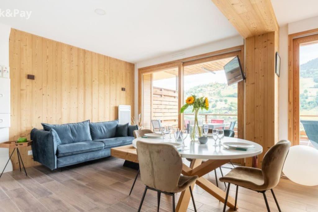 - un salon avec une table et un canapé bleu dans l'établissement Appartement Maïnou à La Bresse, à La Bresse