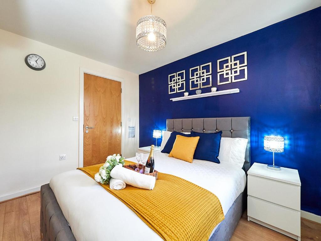 ein Schlafzimmer mit einem großen Bett mit blauer Wand in der Unterkunft Beauchamp Suite in Coventry City Centre for Contractors Professionals Tourists Relocators Students and Family in Coventry