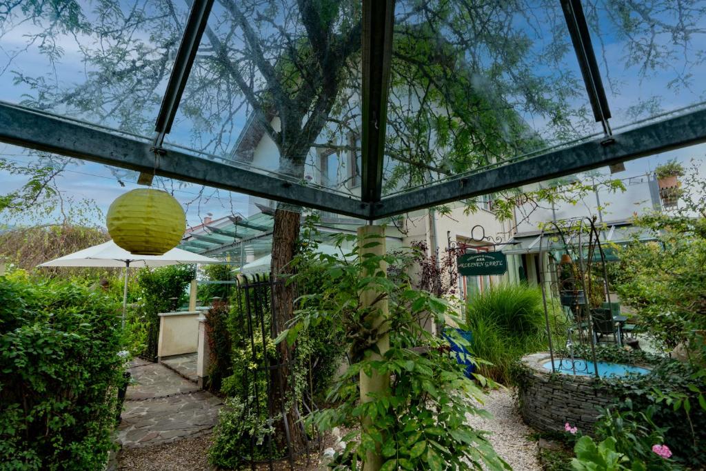 a glass house with a pool in a garden at Ferienhaus Tolazzi in Arnoldstein