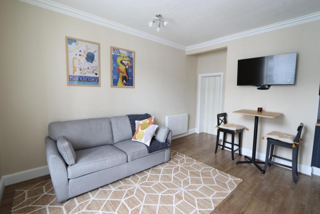 uma sala de estar com um sofá e uma televisão de ecrã plano em Town View em Stourport