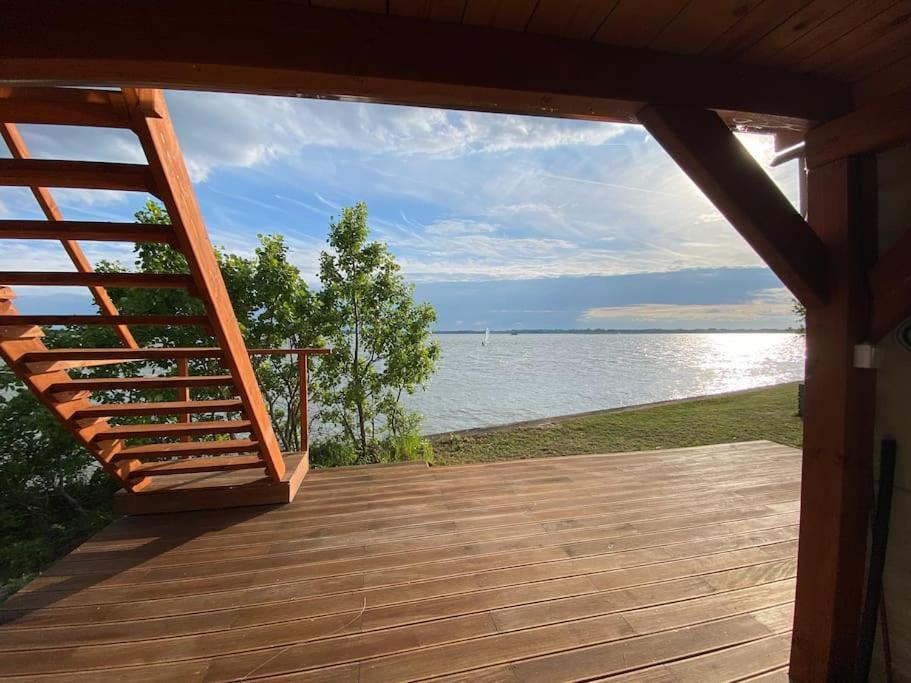 eine Holzterrasse mit Blick auf das Wasser in der Unterkunft Retro house in nature in Šamorín