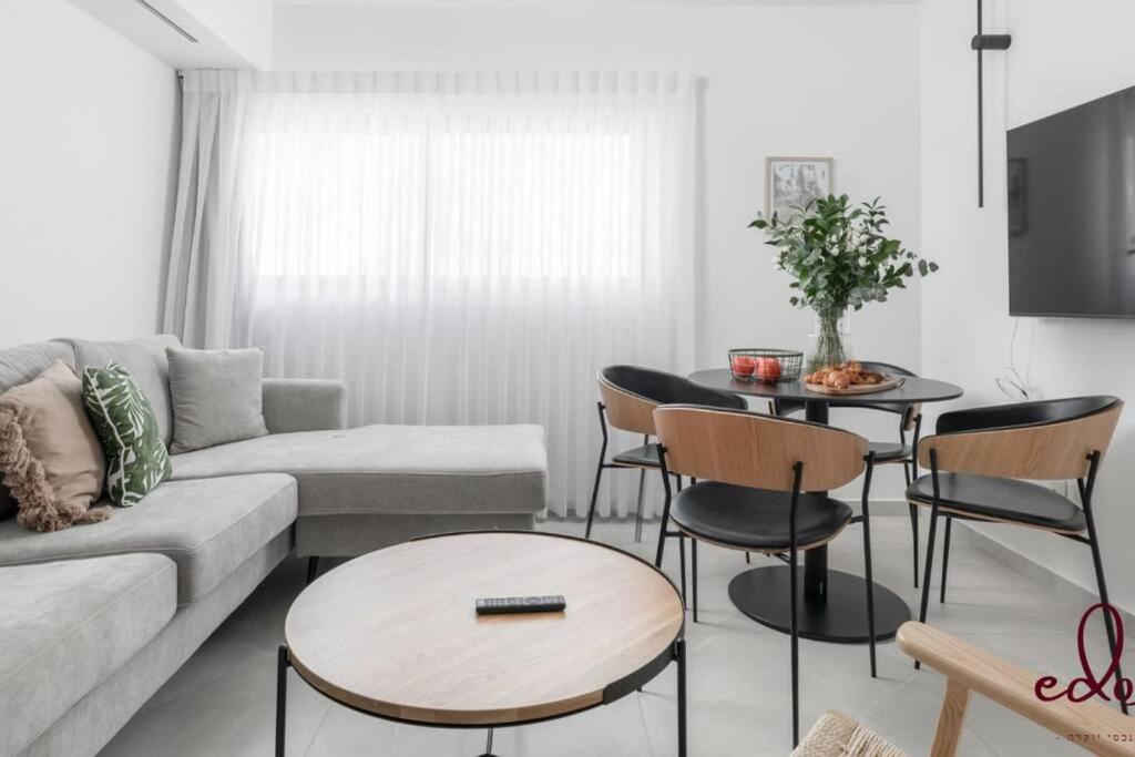 a living room with a couch and a table at דירת 2 חדרי שינה וסלון 50 מטר מהים- By Edomlux in Eilat