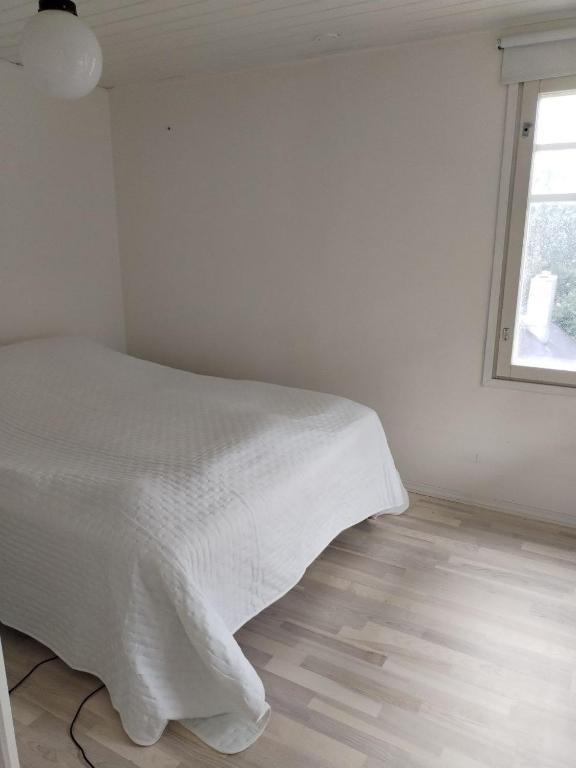 um quarto branco com uma cama e uma janela em Private room in a house w/ pool em Helsínquia