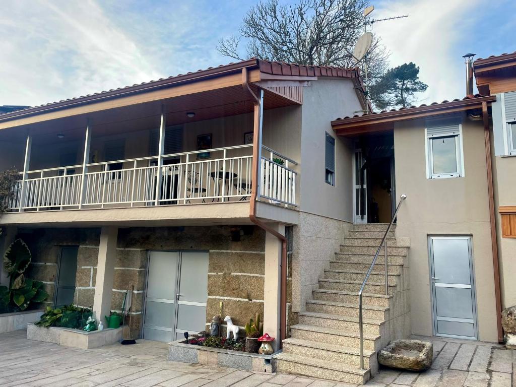 una casa con balcón y escaleras delante en A Casa do Abuelo, en Ourense