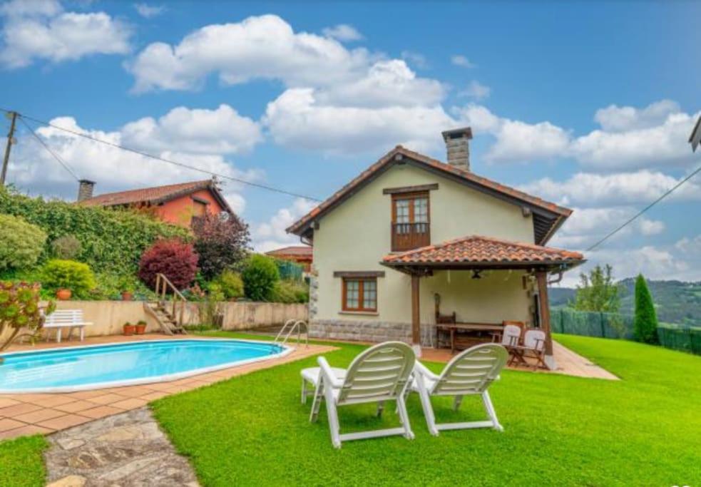 a villa with a swimming pool and a house at La puerta de Fredo in Arboleya