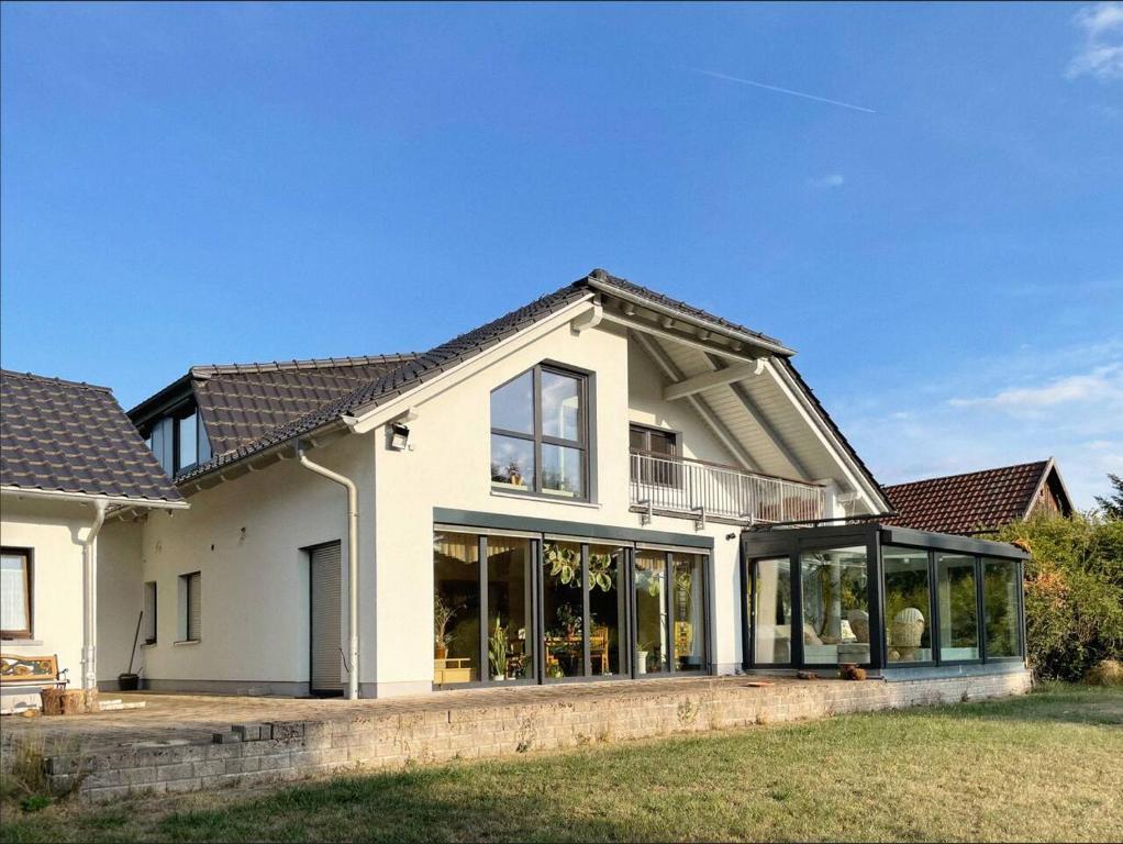 uma grande casa branca com grandes janelas em Urlaub-Im-Erletal em Schleusingen