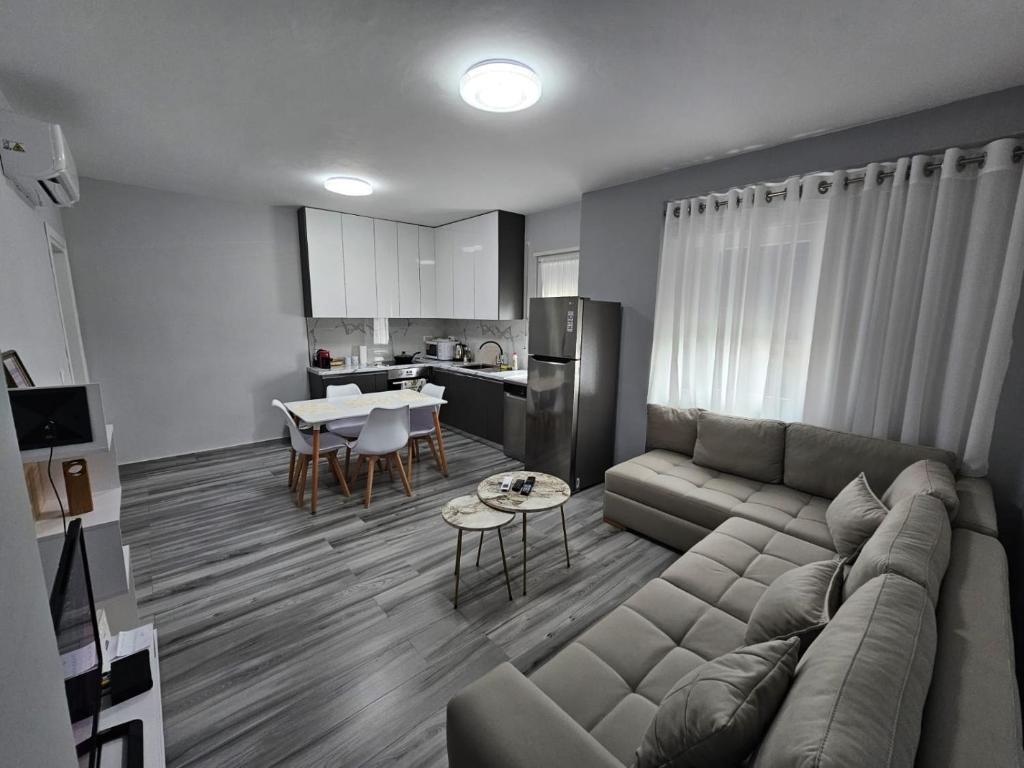 een woonkamer met een bank en een tafel bij Tirana Apartment Comfort Home in Tirana